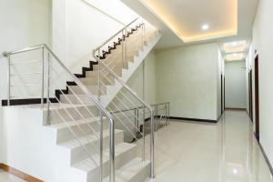 un escalier dans une maison avec une balustrade en verre dans l'établissement RedDoorz near Medan Amplas, à Delitua