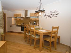 eine Küche und ein Esszimmer mit einem Holztisch und Stühlen in der Unterkunft Ferienwohnung Schütte-Mühle in Schmallenberg