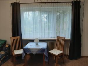 een tafel en twee stoelen voor een raam bij Goode Wind in Norden