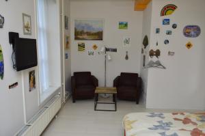 ein Wohnzimmer mit 2 Stühlen und einem TV in der Unterkunft Bed and Breakfast de Kleyne Wereld in Vlissingen