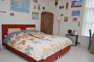 een slaapkamer met een bed met een kleurrijk dekbed bij Bed and Breakfast de Kleyne Wereld in Vlissingen