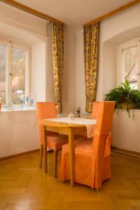 d'une salle à manger avec une table, des chaises et une fenêtre. dans l'établissement Hotel Haus Bauer, à Bad Berneck im Fichtelgebirge