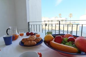 einen Tisch mit Obstteller und Gebäck in der Unterkunft Casa vacanze arianna Otranto centro, Salento 6 posti in Otranto