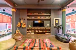 a living room with guitars hanging on the wall at CLOUD on Saladaeng Silom Hostel Bangkok in Bangkok