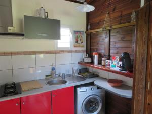 a kitchen with a sink and a washing machine at Bungalow des Palétuviers in Morne-à-lʼEau