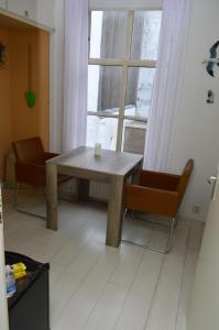a table and two chairs in a room with a window at Bed and Breakfast de Kleyne Wereld in Vlissingen