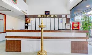 a hotel lobby with a reception counter and stairs at Treebo Trend Atithi Comforts 1 Km From Nisargadhama Forest in Kushālnagar