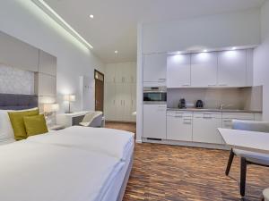 um quarto com uma grande cama branca e uma cozinha em Apartment:house Klosterbau em Neutraubling