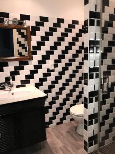 bagno con parete a scacchi in bianco e nero di Residence le Petit Paradis a Labastide-Rouairoux