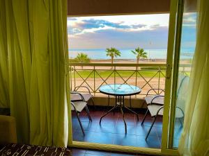 einen Balkon mit einem Tisch und Strandblick in der Unterkunft Porto South Beach Royal Sea view families صف اول بحر مباشر in Ain Suchna