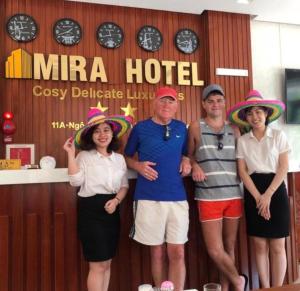 a group of people wearing hats standing in front of a hotel at Mira Hotel Quy Nhơn in Quy Nhon