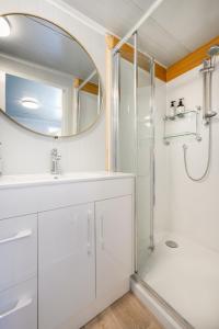 a bathroom with a shower and a sink and a mirror at Cosy cabin to stay even better than Glamping in Pukekohe East