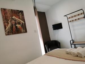 een slaapkamer met een bed met een schilderij aan de muur bij Le Saint Jean in Barbentane