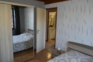 1 dormitorio con 1 cama y puerta que conduce a un baño en chez nous, en Chilhac