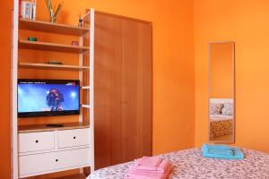 トリノにあるPrima D'Oraのオレンジ色の壁のベッドルーム(テレビ、ベッド付)