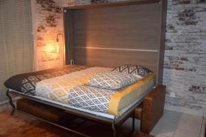 a bed with a wooden headboard in a room at Ces jours en baie Le vue mer in Cayeux-sur-Mer