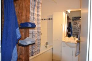 a bathroom with a shower curtain and a sink at Ces jours en baie Le vue mer in Cayeux-sur-Mer