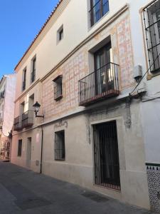 um edifício com janelas e varandas numa rua em Málaga Apartamentos - Jinetes, 23 em Málaga