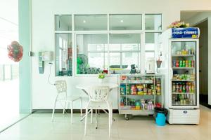 a kitchen with a table and chairs and a refrigerator at Udee Living Place in Hat Yai