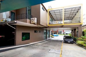 a car parked in a parking lot in front of a building at Udee Living Place in Hat Yai