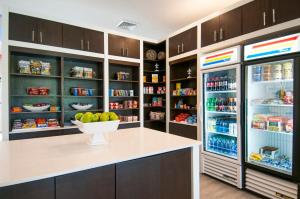 a kitchen with an open refrigerator with a bowl of fruit at Holiday Inn - New Orleans Airport North by IHG in Kenner
