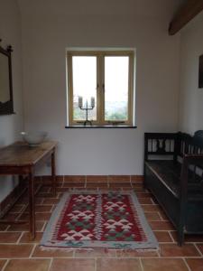 a living room with a rug on the floor and a window at Three Chimneys Farm Accommodation in Goudhurst