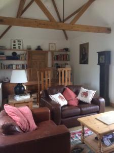 ein Wohnzimmer mit 2 Sofas und einem Tisch in der Unterkunft Three Chimneys Farm Accommodation in Goudhurst