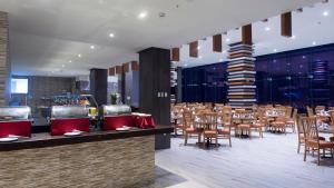 ein Restaurant mit Tischen und Stühlen und eine Bar in der Unterkunft Holiday Inn Coatzacoalcos, an IHG Hotel in Coatzacoalcos