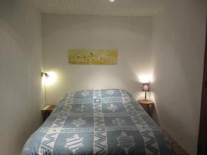 ein Schlafzimmer mit einem blauen und weißen Bett mit zwei Lampen in der Unterkunft Les Bruns in Les Thuiles