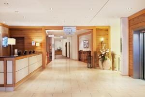 a hallway in a hotel with a lobby with wood walls at Holiday Inn Nürnberg City Centre, an IHG Hotel in Nuremberg