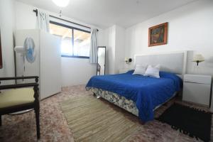 um quarto com uma cama azul e uma janela em Estrella de Mar em La Paloma