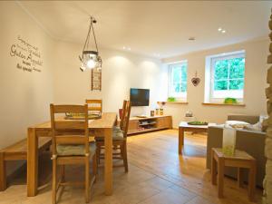 comedor y sala de estar con mesa y sillas en Ferienwohnung Schütte-Mühle, en Schmallenberg