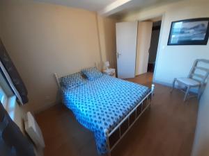 um quarto com uma cama e uma cadeira em F2 de charme au cœur de Rouen, vu unique sur la cathédrale em Rouen