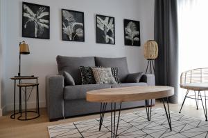Sala de estar con sofá gris y mesa en Calma Suites, en Sevilla