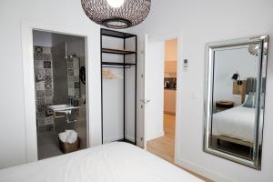 1 dormitorio con espejo y 1 cama en Calma Suites, en Sevilla