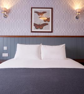 1 dormitorio con 1 cama y una foto de mariposas en Chase Inn By Greene King Inns, en Nuneaton