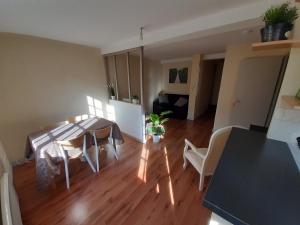 uma cozinha e sala de estar com mesa e cadeiras em F2 de charme au cœur de Rouen, vu unique sur la cathédrale em Rouen