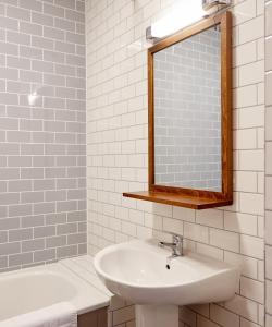 a bathroom with a sink and a mirror and a tub at Chase Inn By Greene King Inns in Nuneaton