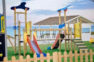 un parque infantil con tobogán y columpio en Golden Tulip Taj Sultan Resort en Hammamet