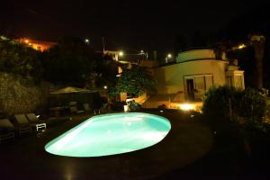 a swimming pool in the yard of a house at night at Villa Sofia in Lerici
