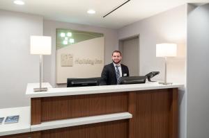 a man is sitting at a reception desk at Holiday Inn Wall Street, an IHG Hotel in New York