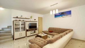 ein Wohnzimmer mit einem Sofa und einem TV in der Unterkunft Luxury Vila compelx Aurora-Mar with 2 pools and 8 bedrooms, 200m from the beach in Banjole