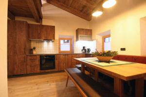 a kitchen with wooden cabinets and a wooden table at Almliesl BRAM-618 in Bramberg am Wildkogel