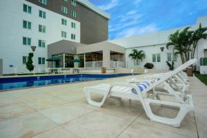 - une piscine avec des chaises longues à côté d'un bâtiment dans l'établissement Holiday Inn Express Tapachula, an IHG Hotel, à Tapachula