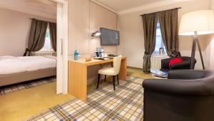 um quarto de hotel com uma secretária e uma cama em Hotel Jagdschloss Kranichstein em Darmstadt