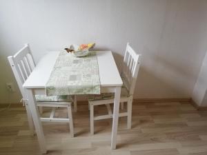 a white table with two chairs and a table and a bowl on it at Haus Maria in Fischbach