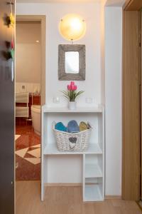 a bathroom with a shelf with a basket of towels at Apartments Sara in Bohinj