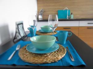 a table with two glasses and a bowl and a bowl at Apartament Pucka Przystań in Puck