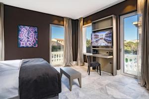 Schlafzimmer mit einem Bett, einem Schreibtisch und Fenstern in der Unterkunft Palazzo Doglio in Cagliari
