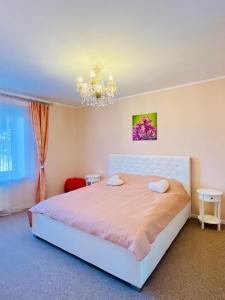 a bedroom with a white bed and a chandelier at Love Apartment Riga in Rīga